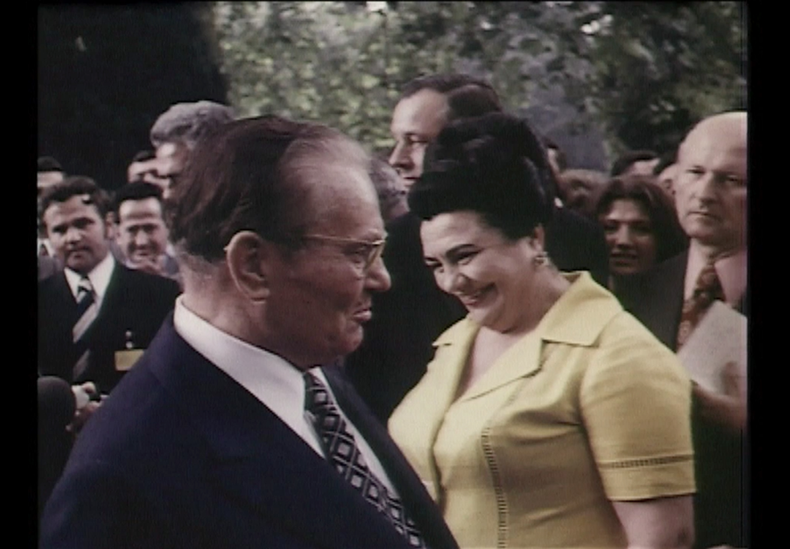 Josip Broz Tito mit seiner Frau Jovanka Broz inmitten einer Menschengruppe