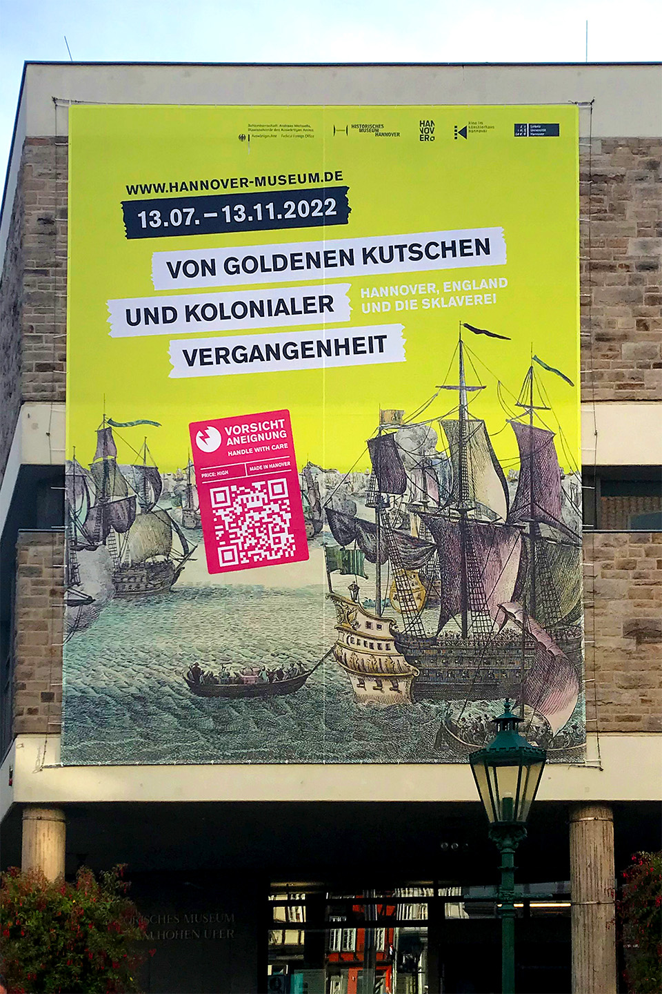 Stoffbanner zur Ausstellung 'Von goldenen Kutschen und kolonialer Vergangenheit' an der Außenfassade des Historischen Museums Hannover