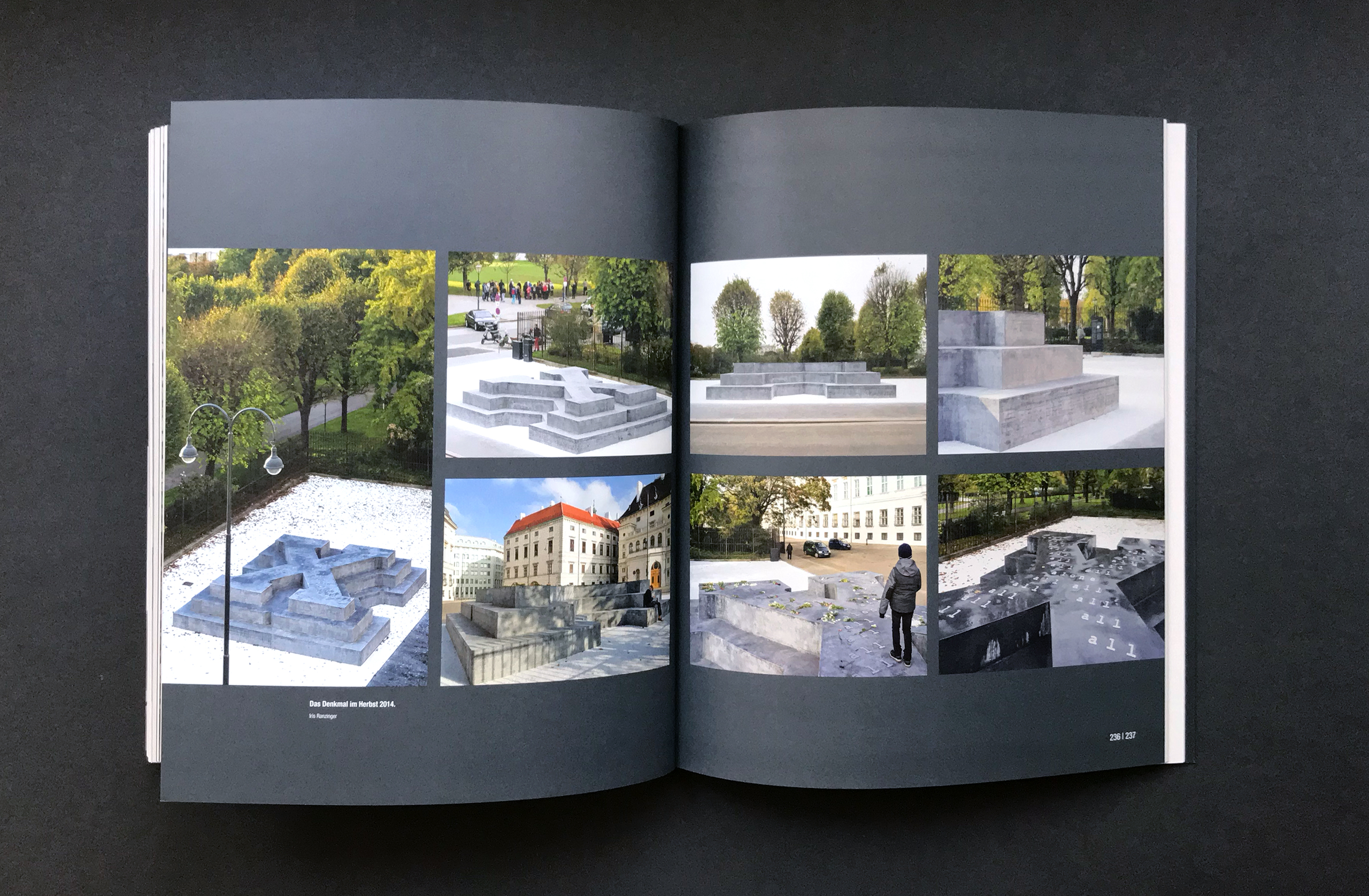 Aufgeschlagene Doppelseite des Katalogs mit mehreren Farbfotografien des Denkmals für die österreichischen Verfolgten der NS-Militärjustiz am Ballhausplatz in Wien