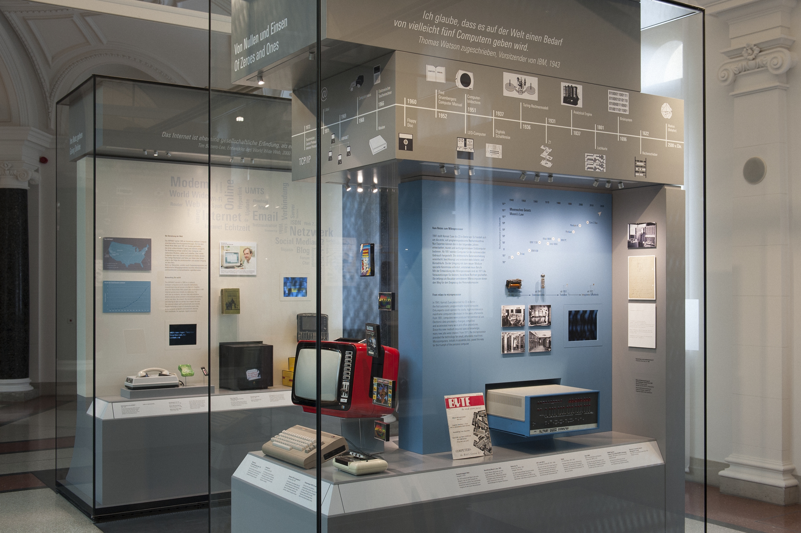 Museumsvitrine mit historischen Computern und Informationsgrafiken zur Entwicklung von Computern im Hintergrund