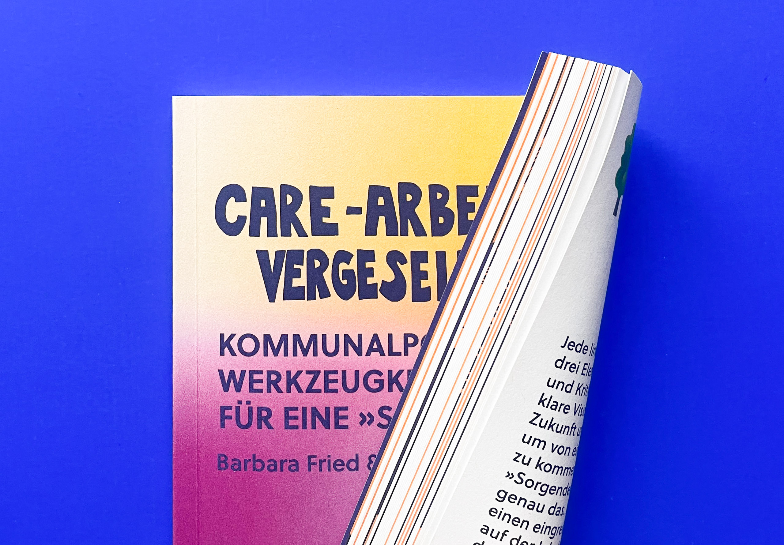 Buchschnitt der Broschüre mit den ungleichmäßig verteilten Farben weiß, orange und dunkelblau