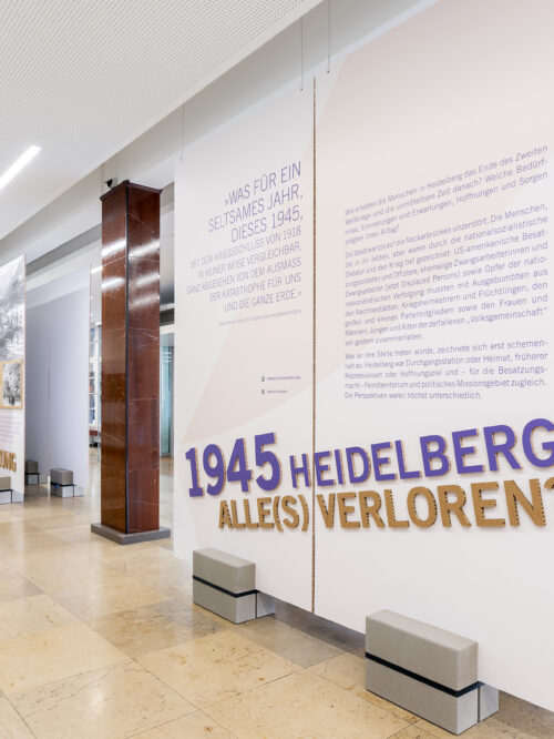 Weitläufiger heller Raum mit großen Text- und Bildtafeln, auf einer Tafel steht groß '1945 HEIDELBERG ALLES VERLOREN'