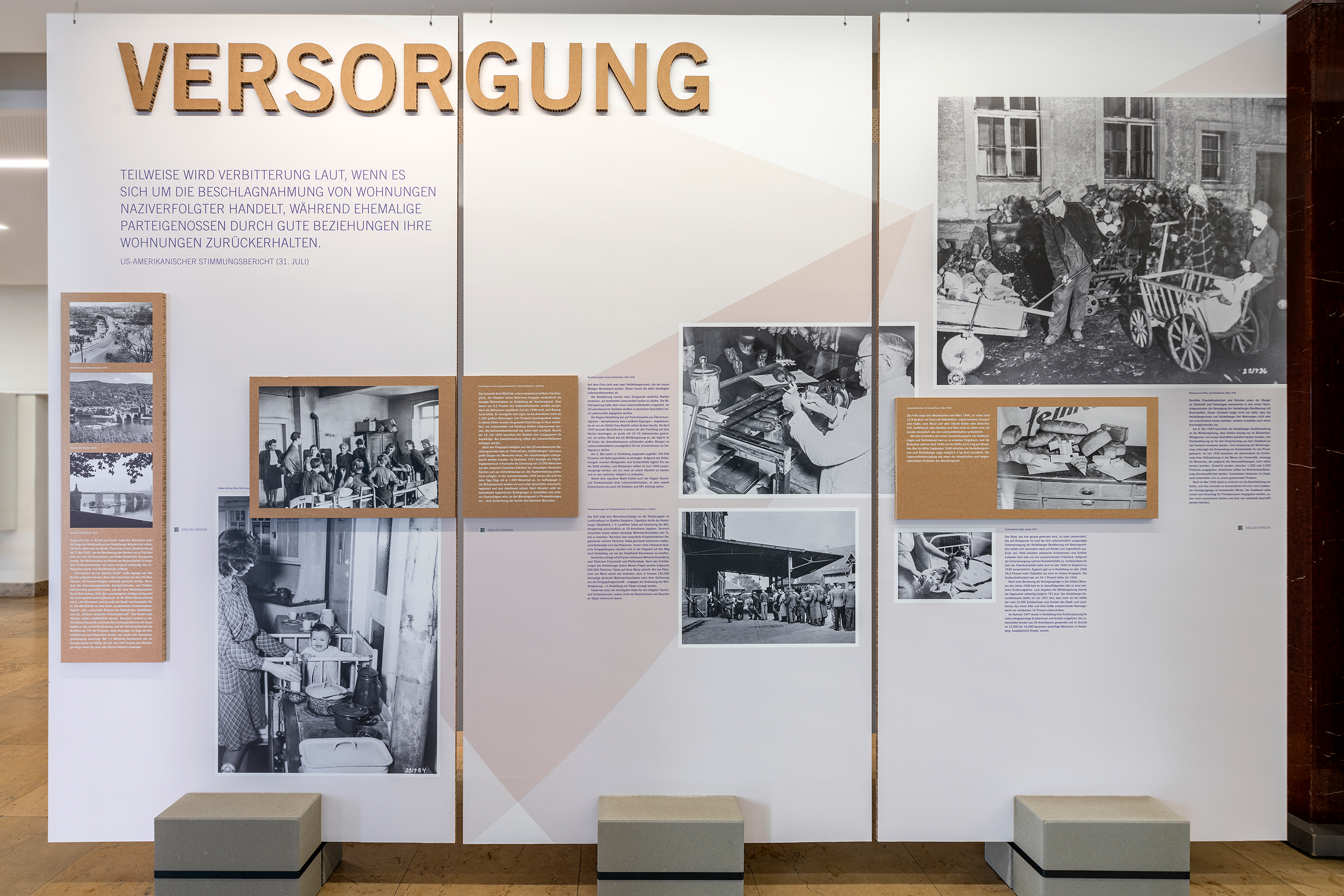 Ausstellungstafel mit der Überschrift 'VERSORGUNG' und mehreren historischen schwarz-weißen Fotografien sowie erklärenden Texten