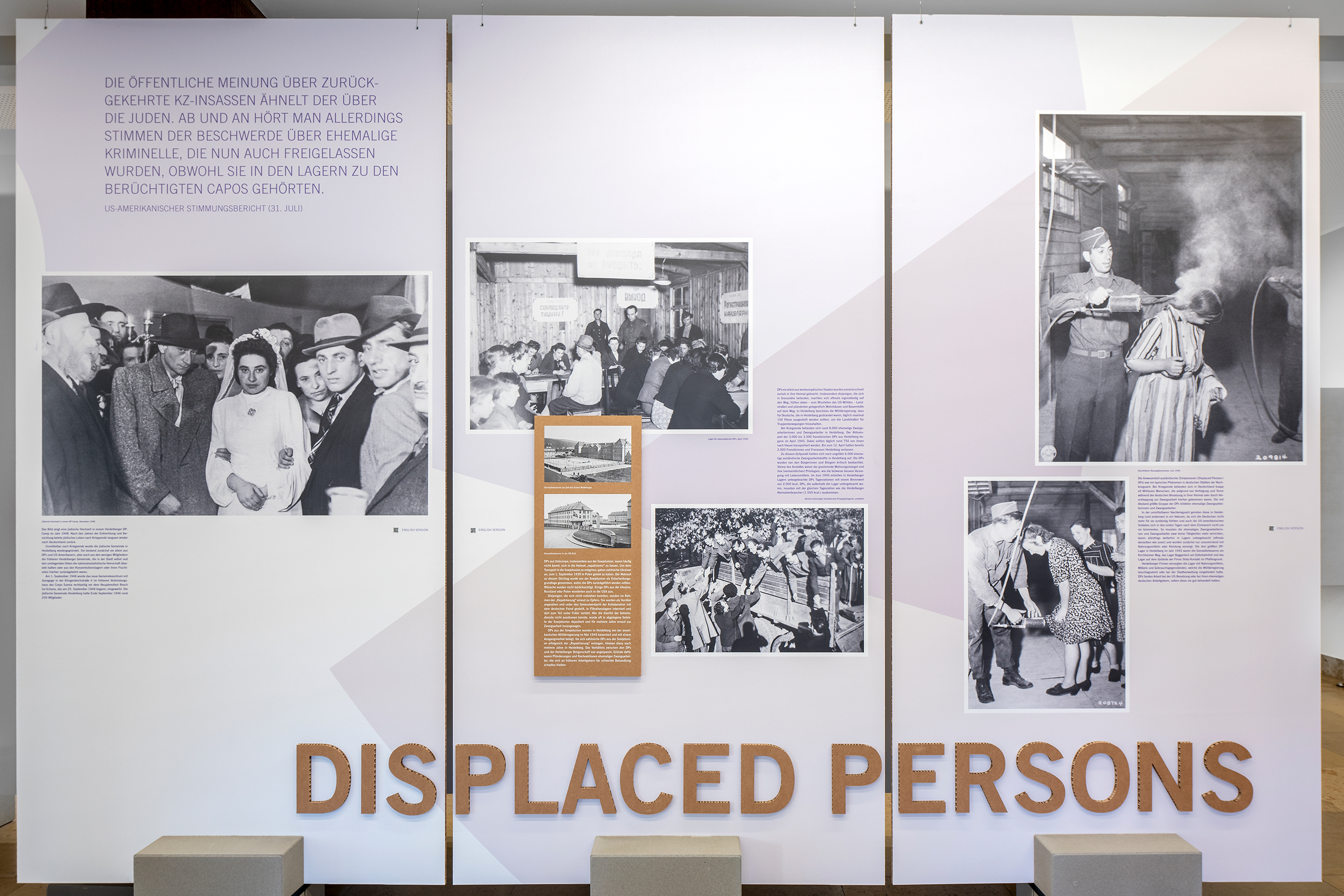 Ausstellungstafel mit dem Thema 'Displaced Persons' und mehreren historischen schwarz-weißen Fotografien sowie erklärenden Texten
